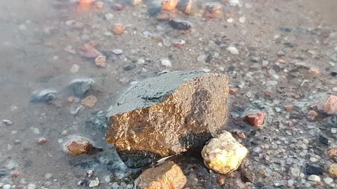 Small waves hit the sand and small rocks Видео 337681733