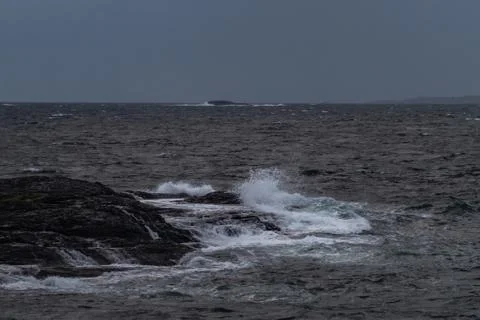 Small waves hitting black rocks from the tlantic ocean Stock Photos