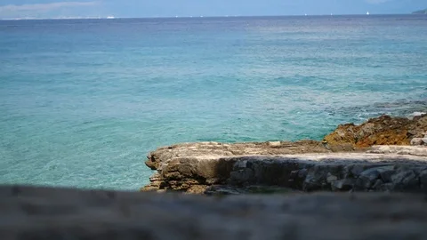 Small waves hitting rocks on beach Stock Footage 112823241
