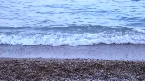 Small waves lapping on a pebble beach Stock Footage 77862873