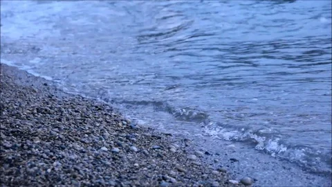 Small waves lapping on a pebble beach Stock Footage 77862894