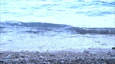 Small waves lapping on a pebble beach Stock Footage 77862915