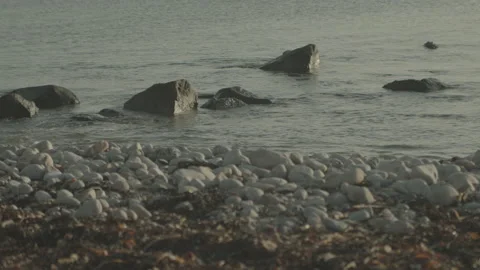Small Waves Lapping Rocky Shore In Irish Winter Afternoon Sun Stock Footage 149829344