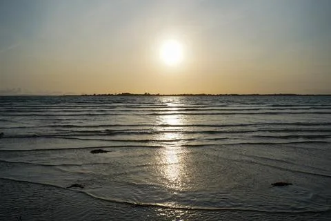 Small waves lapping up on a sandy beach Stock Photos