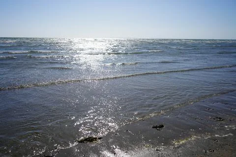 Small waves lapping up on a sandy beach 库存照片