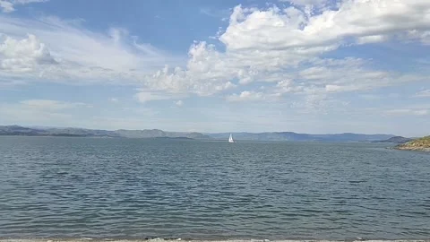 Small waves. Mountains in the distance. Clouds. The yacht is moving. Stock Footage 335458758