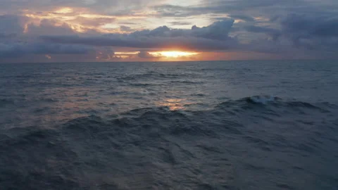 Small waves on ocean surface during warm evening light. Blue ocean in orange Stock Footage 148709779