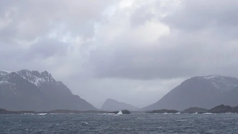 Small waves on ocean surface with mountain ranges in the distance Stock Footage 113227518
