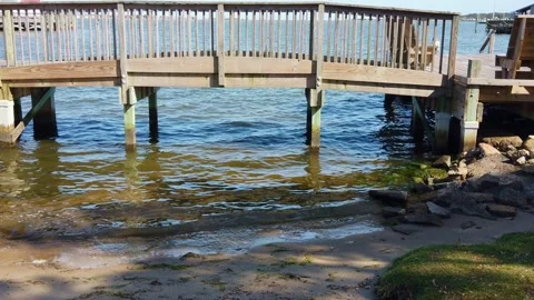 Small Waves Passing By Under Wooden Bridge With rocks Stock Footage 231715659