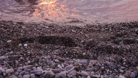 Small waves on a pebble-pebble beach in the calm of the day Stock Footage 265173805