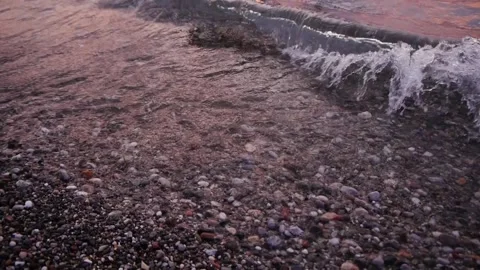 Small waves on a pebble-pebble beach in the calm of the day Stock Footage 265173807