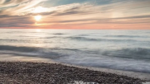 Small waves on pebble shores while sun sets 스톡 동영상 72902028