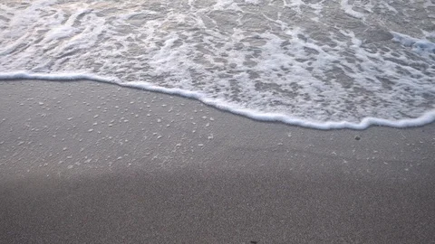 Small waves reaching the shore of a beach Stock Footage 125390118