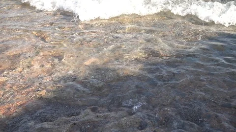 Small waves reaching the shore of a beach Stock Footage 125673702