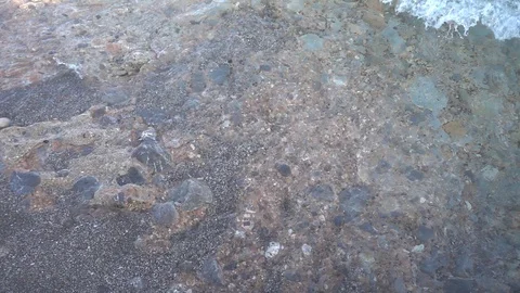 Small waves reaching the shore of a beach Stock Footage 125674362