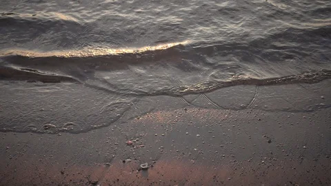 Small waves reaching the shore of a beach Stock Footage 125676198