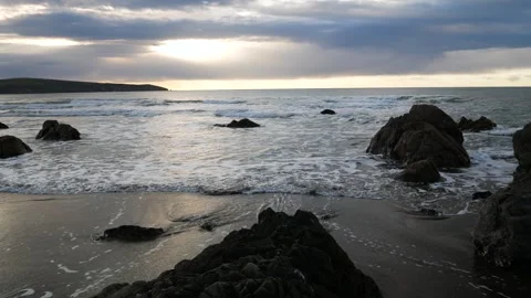Small waves on a rocky beach on a cloudy day Video stock 246389804