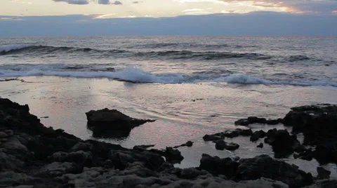 Small waves on a rocky shoreline during sunset Stock Footage 34133061