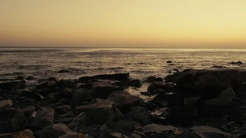Small waves roll ashore at sunset Video stock 81440867