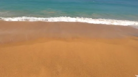Small waves roll on a beautiful golden sandy beach. Stock Footage 242166582