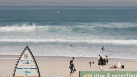 Small waves roll into Bondi Beach and signs show the surfers code and Video stock 138314752
