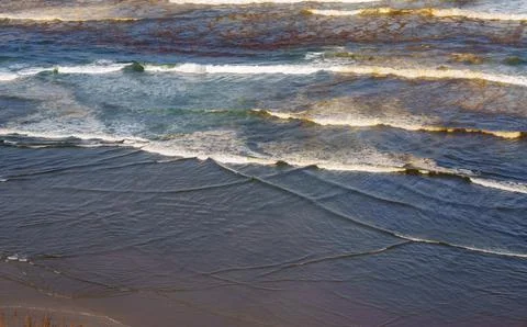 Small waves roll in an break on Ripiro Beach creating coastal pattern with .. Stock Photos