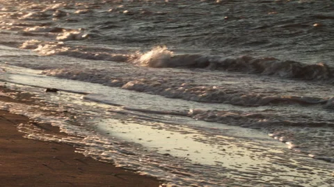 Small Waves Rolling into Shore and Glistening at Sunset with Pink Lens Flare Stock Footage 185096847