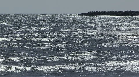 Small waves rolling in on sunny day by the beach Stock Footage 48844083
