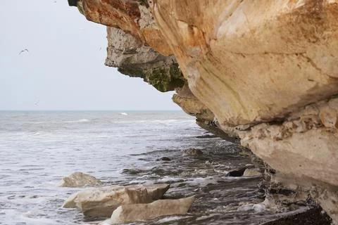 Small waves rolling under the limestone cliff at Bulbjerg in Denmark Stock Photos