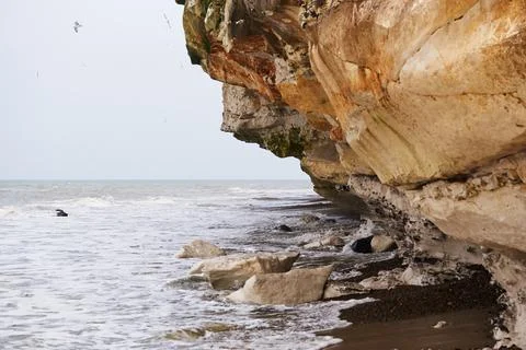 Small waves rolling under the limestone cliff at Bulbjerg in Denmark Stock Photos