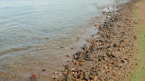 Small waves run over the sandy seashore with small pebbles, close-up 動画素材 139850183