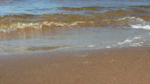 Small waves run on the sandy shore, close-up Stock Footage 139850283
