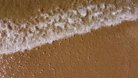 Small waves &amp; sand top view with pan on empty beach in Caparica, Portugal 4K Video stock 154460345