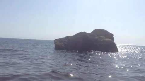Small Waves at sea , Big Black stone in the water and Blue Sky Without Clouds Stockbeeldmateriaal 119687949