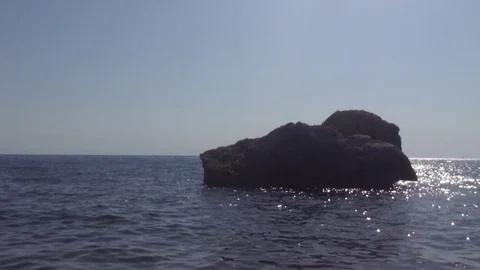 Small Waves at sea , Big Black stone in the water and Blue Sky Without Clouds 2 Stock Footage 119687960