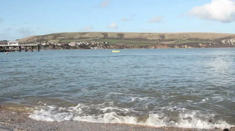 Small waves on the shore town and hills in back Stock Footage 35242487
