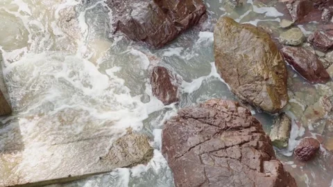 Small waves slowly roll over the rocks. foaming between rocks in the south .. Stock-Footage 250812217