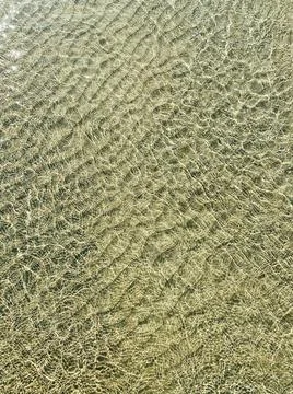 Small waves on the transparent clear water of the sea. Sun glare on the surface Stock Photos