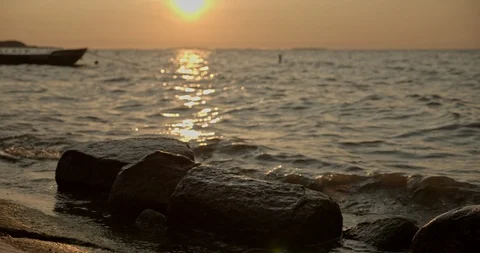 Small waves turn in morning light, boat silhouette, tracking shot, slow motion Stock Footage 115603210