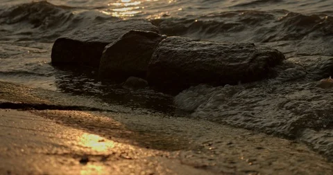 Small waves turn in morning light, tracking shot, slow motion Vídeo Stock 115603590