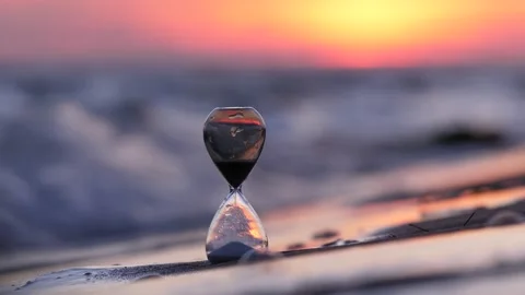 Small waves wash around and then one splash and hourglass fall down in water 스톡 동영상 169177618