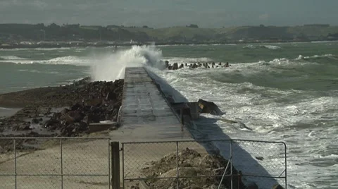 Small waves washing down seawall away from camera Stock Footage