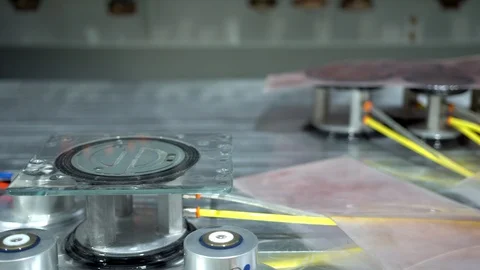 Small wet glass panel on an air sucker piston which is holding it still on Stock-Footage 124258000