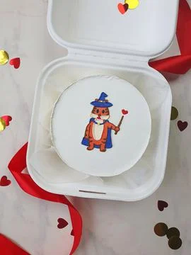 Small white bento cake with a drawnwizard tiger as a gift for the holiday Foto stock
