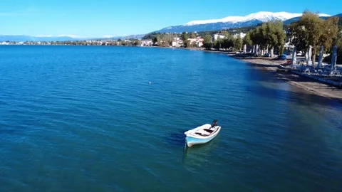 Small white boat floating on crystal clear sea near mountain coast Stock Footage 343994128