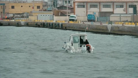 A small white boat sails through the water channel. Video stock 238479148