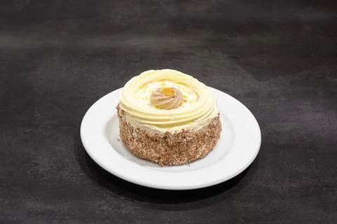 A small white cake with a yellow frosting Stock Photos