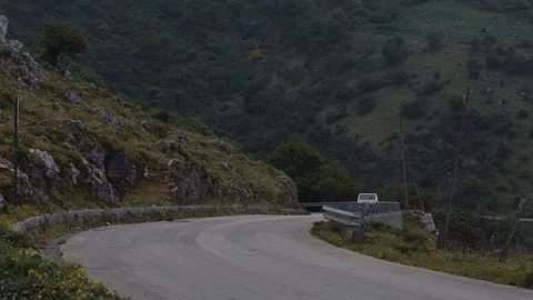 A small white car driving on a small road on a hill Stock Footage 88712336