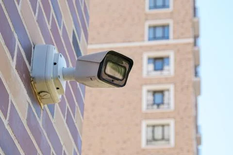 Small white CCTV cameras on a pole against the background of a modern high-ri Stock Photos