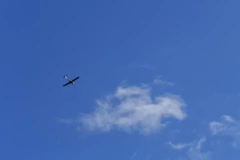 Small white cessna single propeller plane flying in a clear blue sky Stock Photos